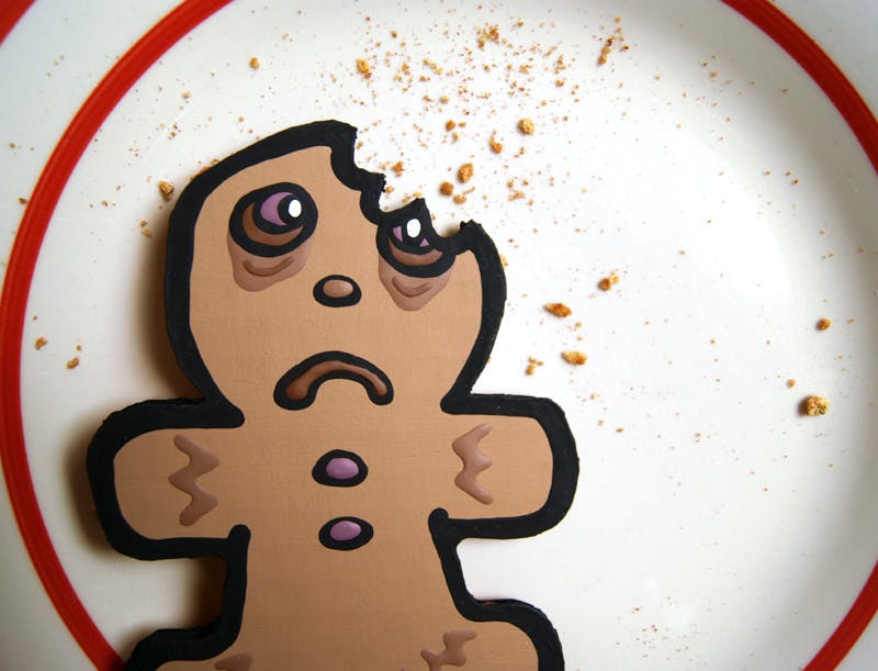 Gingerbread cardboard cutout in the shape of a cookie with a bite taken out